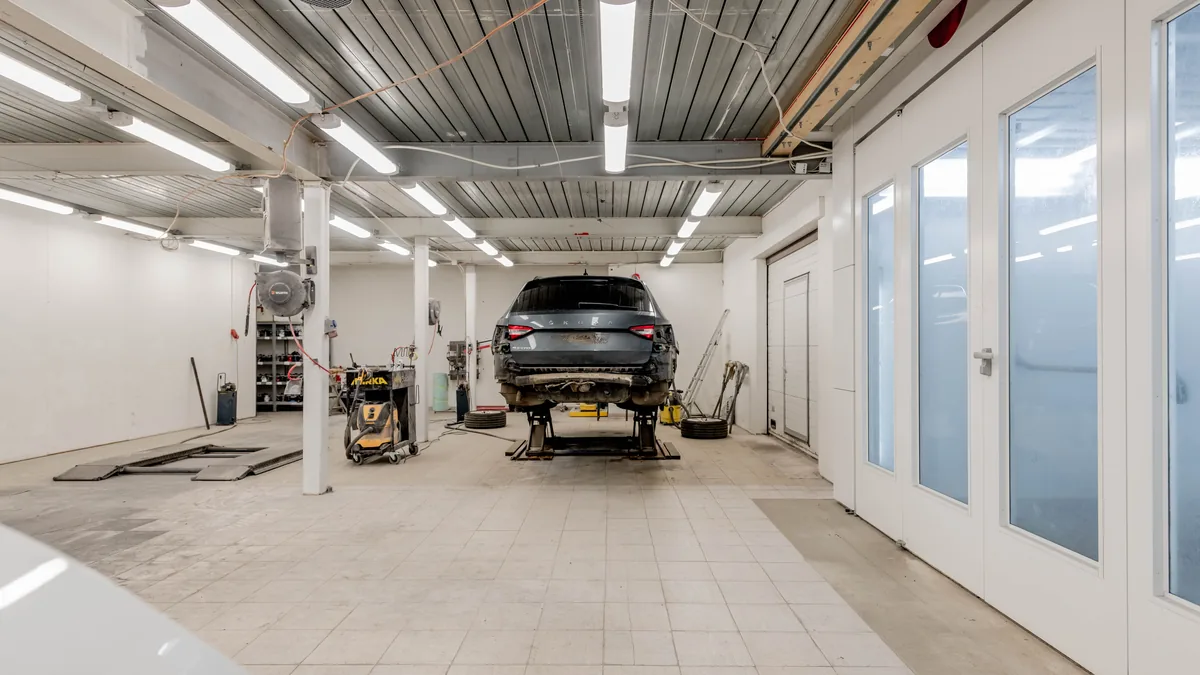 Auto repair shop bay with a car raised on a hydraulic lift