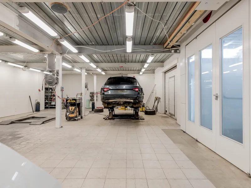 Auto repair shop bay with a car raised on a hydraulic lift