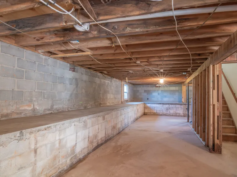 Unfinished basement with bare concrete floor and exposed structure, ready for a floor coating