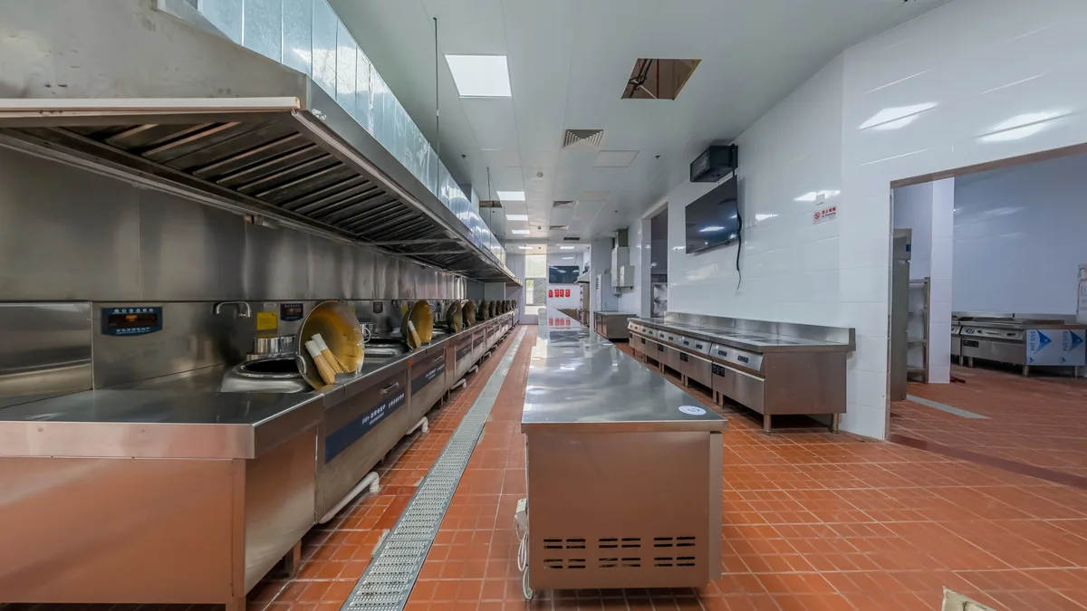 Commercial kitchen interior with stainless steel equipment and a washable floor