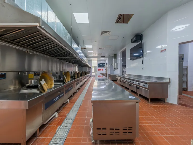 Commercial kitchen interior with stainless steel equipment and a washable floor
