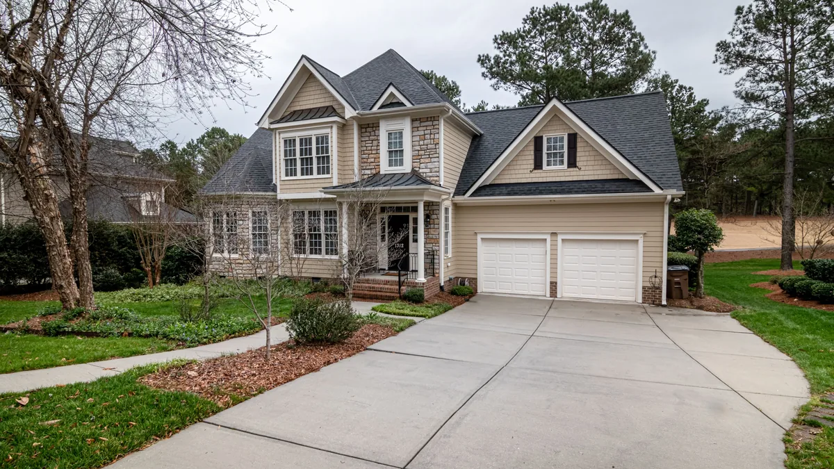 Suburban house with a two-car garage and a wide concrete driveway
