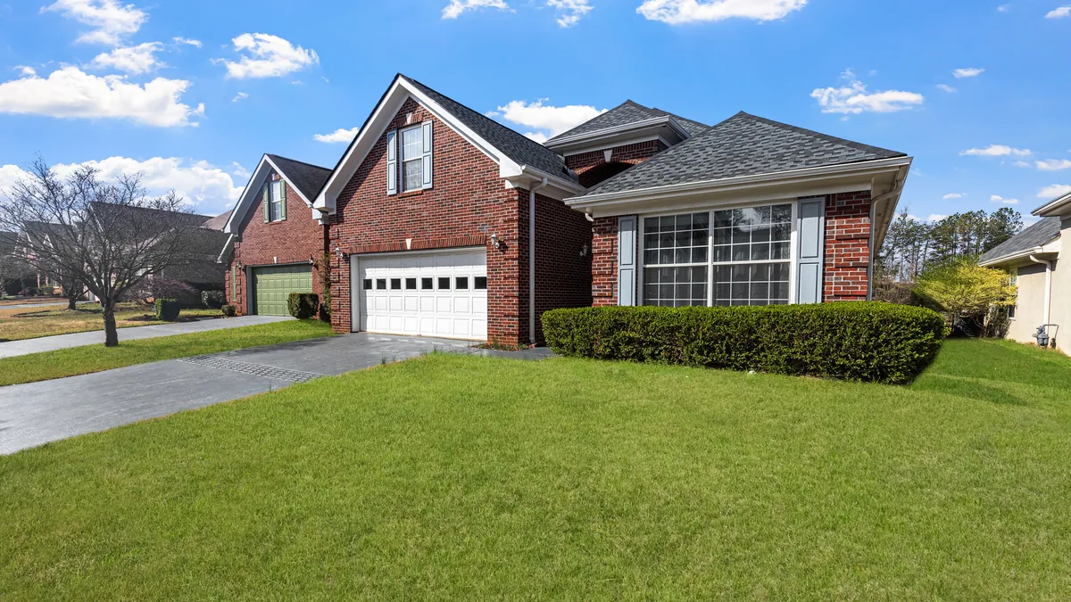Red brick suburban house with a well-kept front lawn