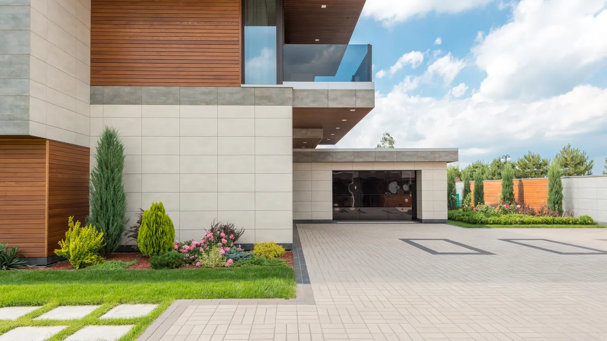 Newly built house with a wide driveway and fresh landscaping
