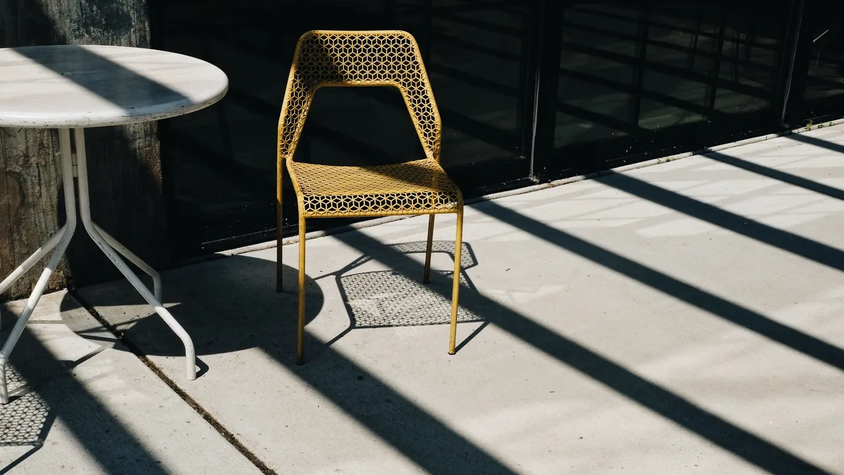 Outdoor concrete patio with garden furniture in afternoon sun