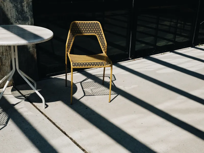 Outdoor concrete patio with garden furniture in afternoon sun