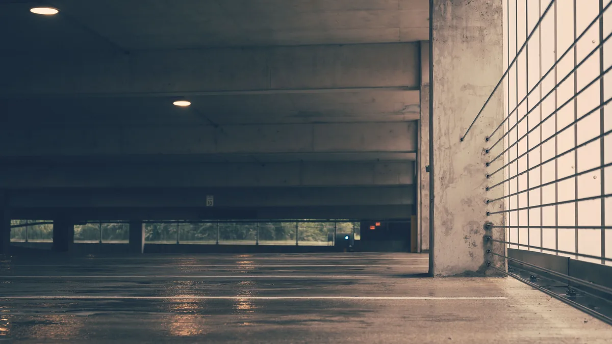 Indoor parking structure with a sealed concrete floor reflecting overhead light
