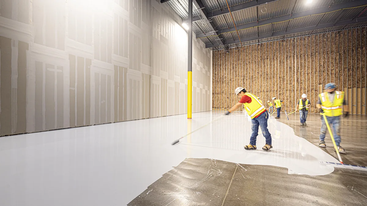 Concrete floor being placed and finished by workers on site