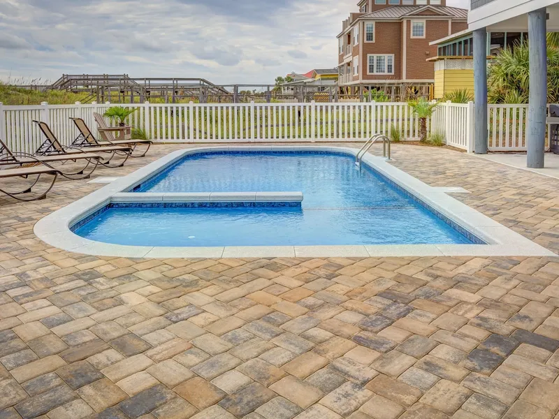 Pool deck surround with sun loungers beside a swimming pool